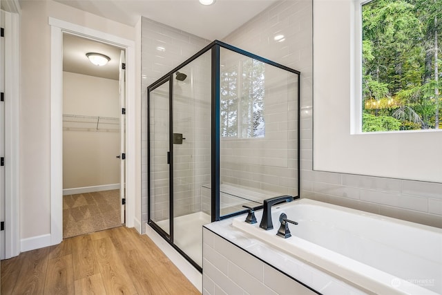 bathroom with plus walk in shower and wood-type flooring