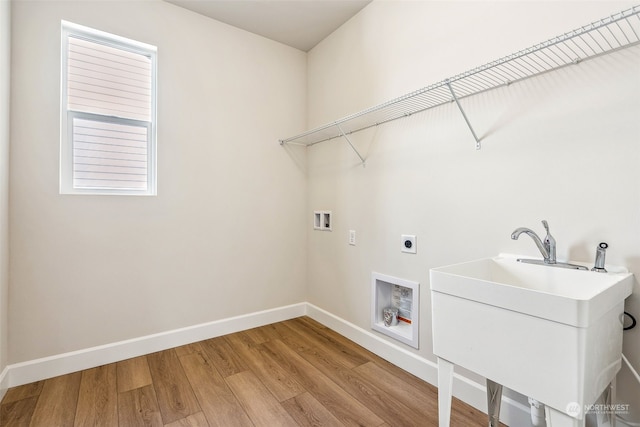 laundry room with sink, electric dryer hookup, washer hookup, and light hardwood / wood-style flooring