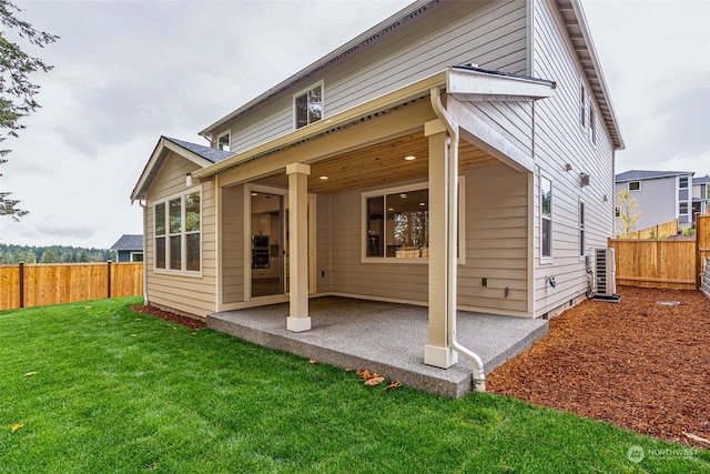 back of property with cooling unit, a patio, and a lawn