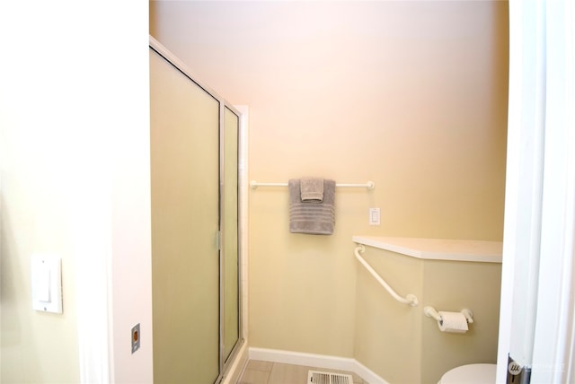 bathroom with toilet and a shower with shower door