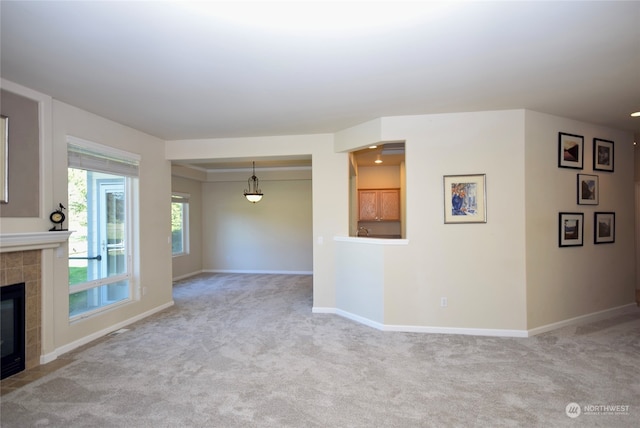 unfurnished living room featuring light carpet and a fireplace