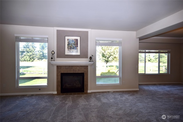 unfurnished living room with a fireplace and dark colored carpet