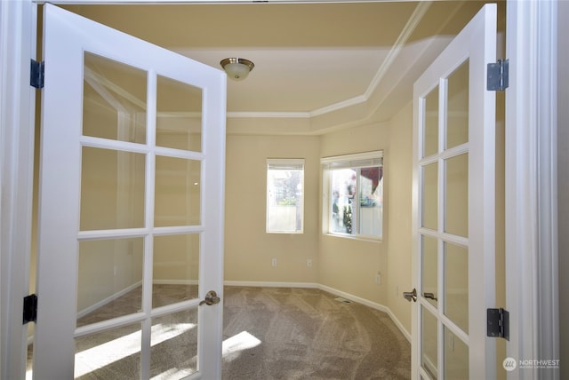 spare room featuring french doors, crown molding, and carpet