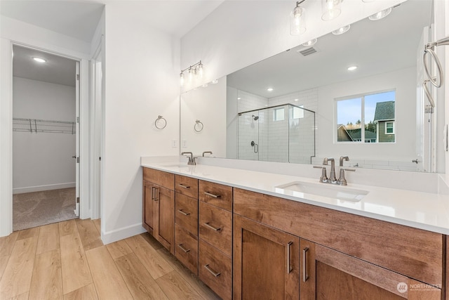 bathroom featuring vanity, wood-type flooring, and walk in shower