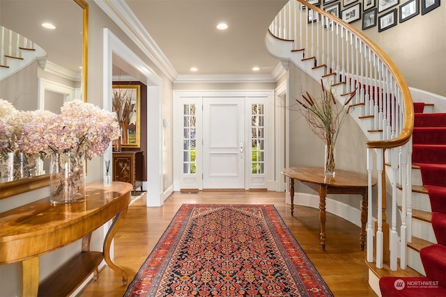 foyer featuring light wood-type flooring and crown molding