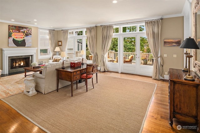 living room with plenty of natural light, ornamental molding, and light wood-type flooring