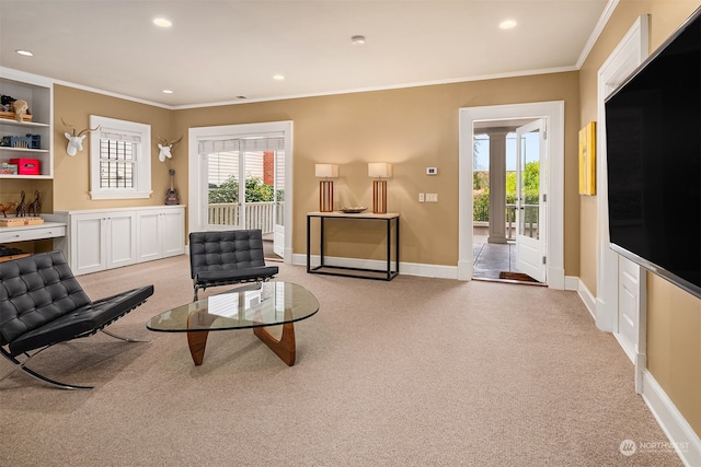 carpeted living room with ornate columns and ornamental molding