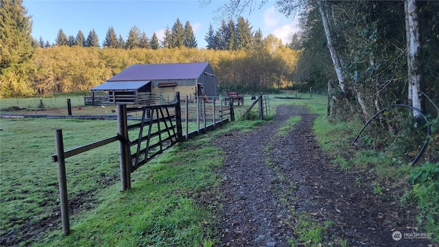 3955 Clearwater Rd, Forks, WA 98331 - view of yard featuring an outdoor structure, a wooded view, a pole building, a rural view, and fence