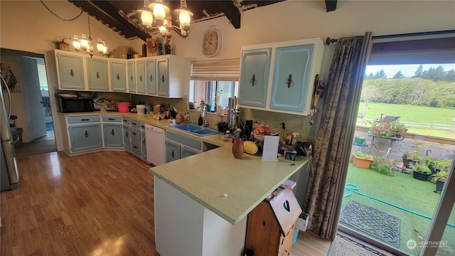 kitchen with a notable chandelier, hanging light fixtures, kitchen peninsula, and plenty of natural light