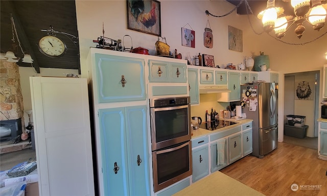 kitchen featuring light hardwood / wood-style floors, a chandelier, and stainless steel appliances