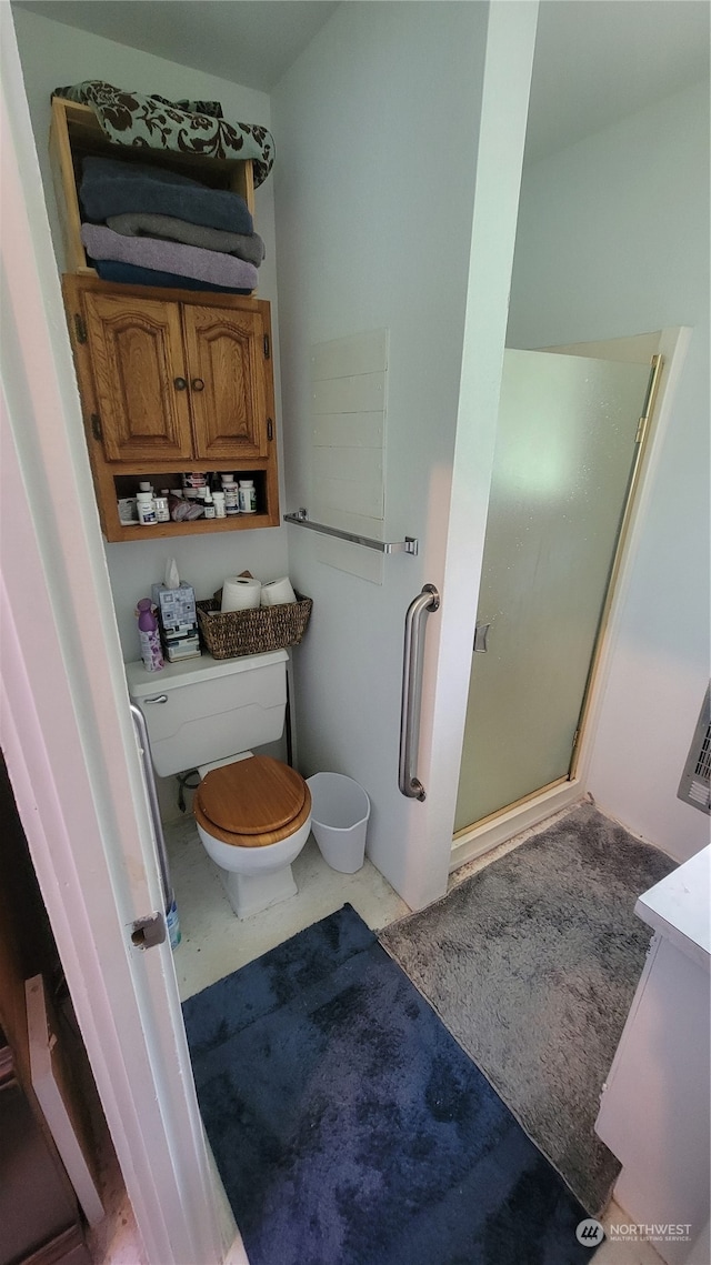 bathroom with vanity, toilet, and a shower with shower door