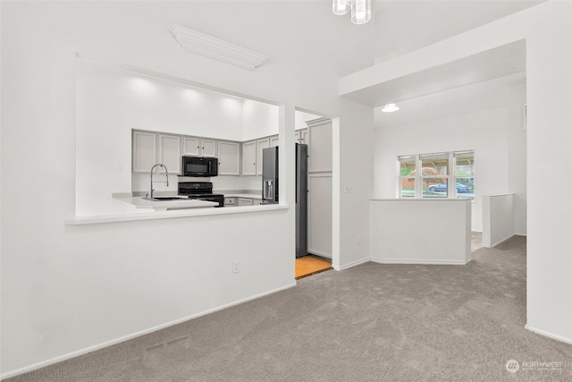 kitchen featuring light colored carpet, black appliances, sink, and gray cabinets