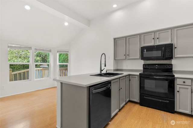 kitchen with sink, kitchen peninsula, black appliances, lofted ceiling with beams, and light hardwood / wood-style floors