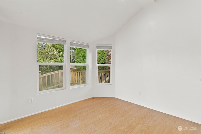 empty room featuring light hardwood / wood-style floors and vaulted ceiling