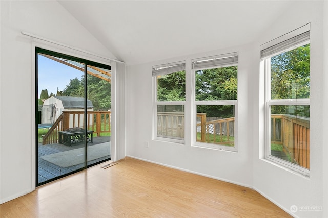 unfurnished sunroom featuring vaulted ceiling