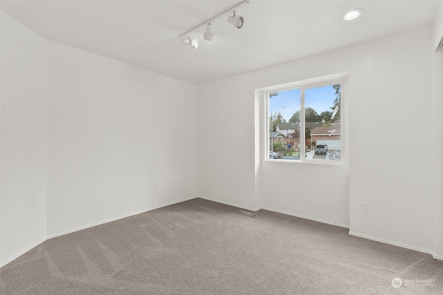 unfurnished room featuring carpet floors and rail lighting