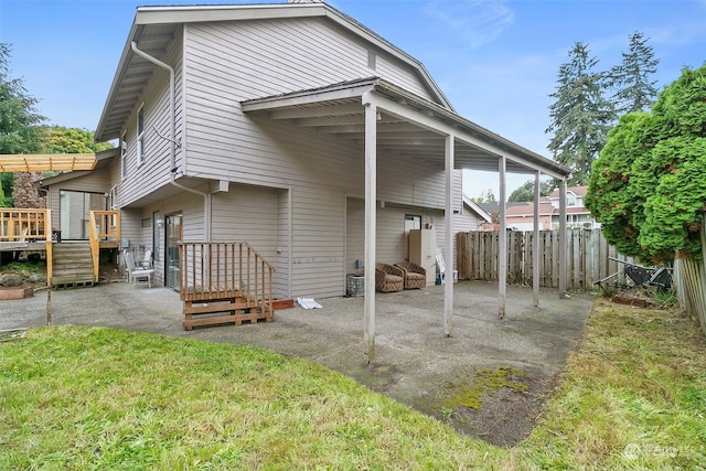 back of house with a yard and a patio