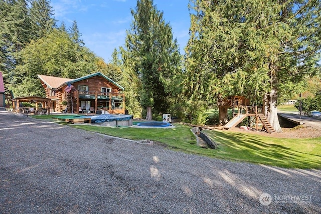 view of yard with a covered pool and a playground