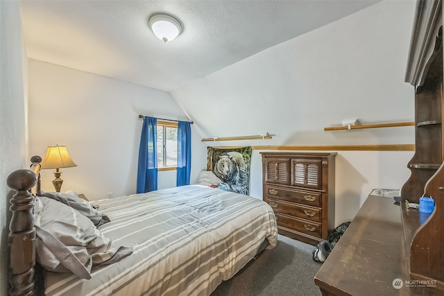 carpeted bedroom with a textured ceiling and lofted ceiling