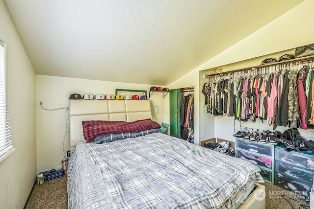 bedroom featuring a textured ceiling, vaulted ceiling, carpet flooring, and a closet