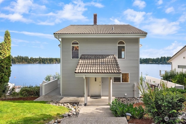 2210E Mason Lake Dr W, Grapeview, WA 98546 - rear view of house featuring a tile roof, a chimney, a water view, and a lawn