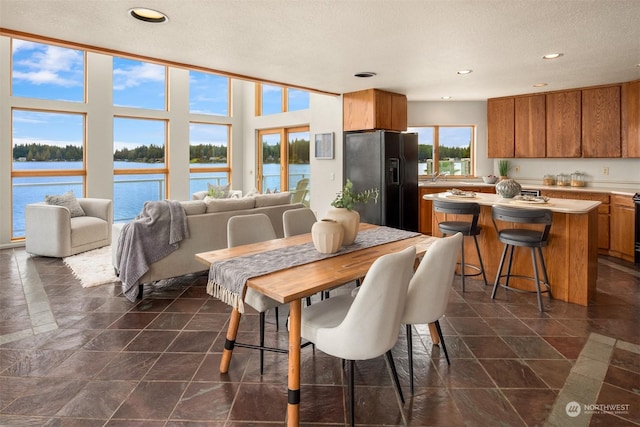 2210E Mason Lake Dr W, Grapeview, WA 98546 - dining area with a water view, recessed lighting, and dark stone finish floors