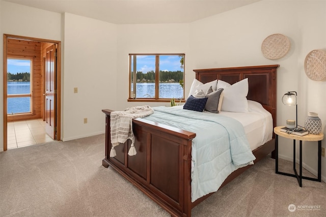 2210E Mason Lake Dr W, Grapeview, WA 98546 - bedroom with light carpet, a water view, and baseboards