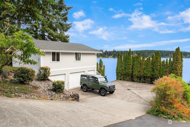 2210E Mason Lake Dr W, Grapeview, WA 98546 - view of home's exterior with concrete driveway, a water view, an attached garage, and a wooded view