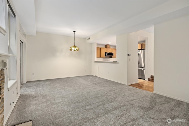 unfurnished living room with stairs, visible vents, baseboards, and carpet flooring