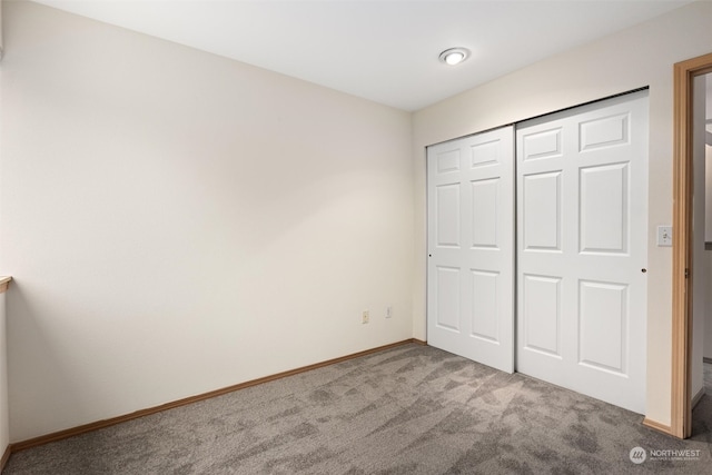 unfurnished bedroom with a closet, baseboards, and carpet