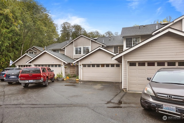 view of front of house featuring roof with shingles and driveway