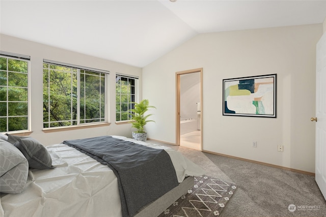 carpeted bedroom with vaulted ceiling, baseboards, and ensuite bathroom