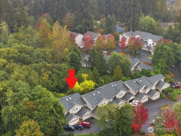 drone / aerial view featuring a residential view and a wooded view