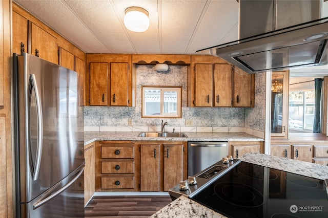 kitchen with sink, a textured ceiling, dark wood-type flooring, ventilation hood, and appliances with stainless steel finishes