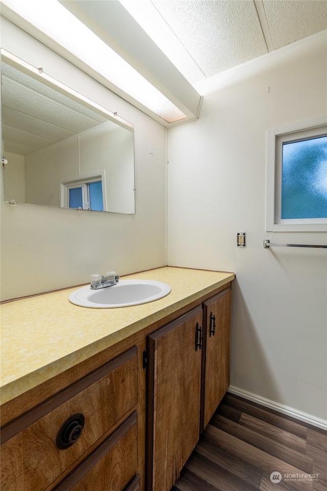 bathroom featuring hardwood / wood-style flooring, vanity, and a textured ceiling