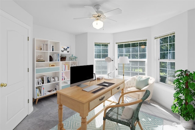 carpeted office space featuring ceiling fan and plenty of natural light