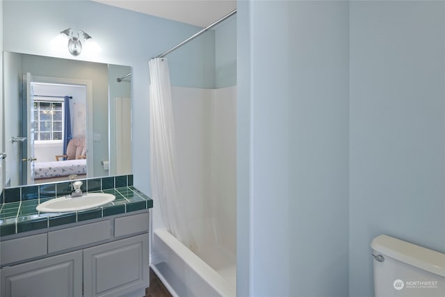 full bathroom featuring shower / tub combo with curtain, vanity, and toilet