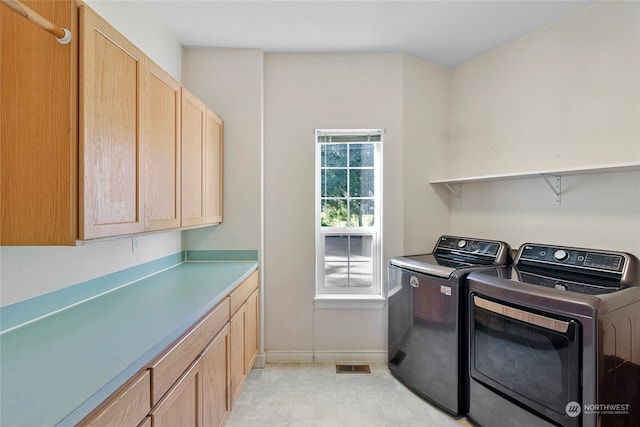 washroom with cabinets and washer and dryer