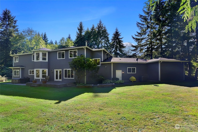 rear view of property featuring a yard and a patio area