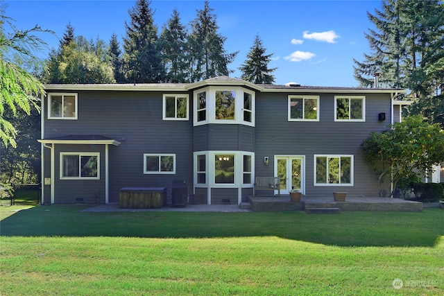 back of property with a yard and a patio