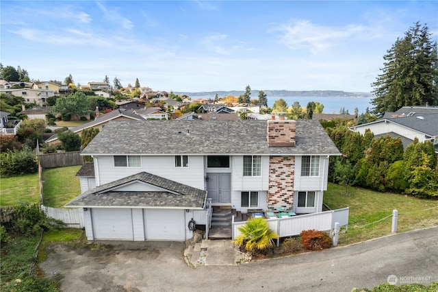 view of front facade featuring a front lawn and a water view