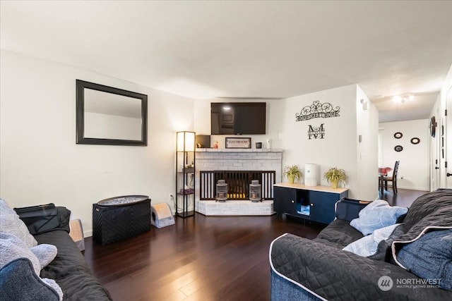 living room with dark hardwood / wood-style floors and a brick fireplace