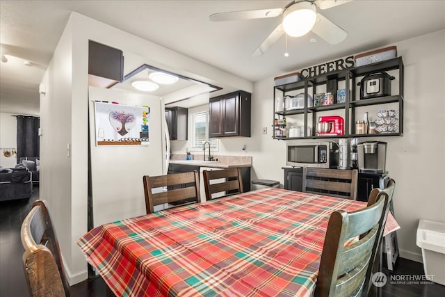 dining space with sink, hardwood / wood-style flooring, and ceiling fan