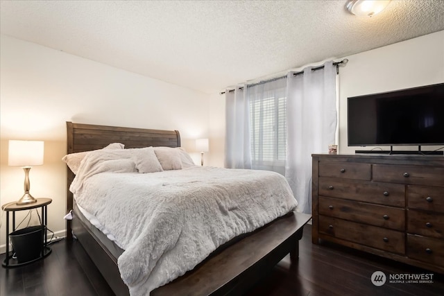 bedroom with a textured ceiling and dark hardwood / wood-style floors