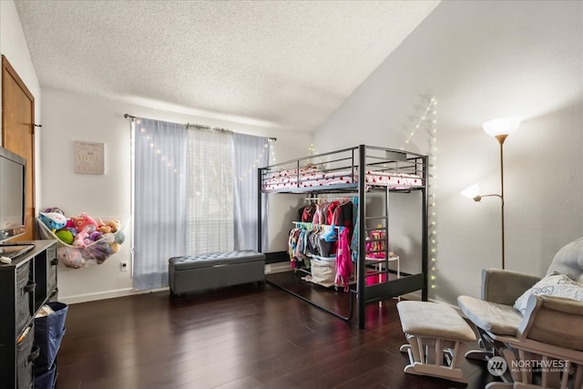 bedroom featuring lofted ceiling, a textured ceiling, and dark hardwood / wood-style flooring