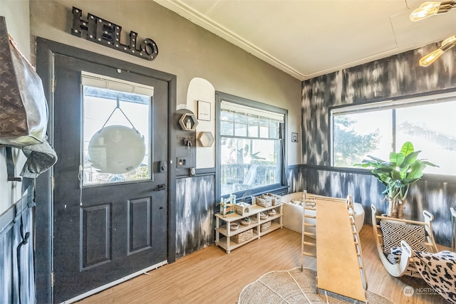 interior space with wood-type flooring, plenty of natural light, and crown molding