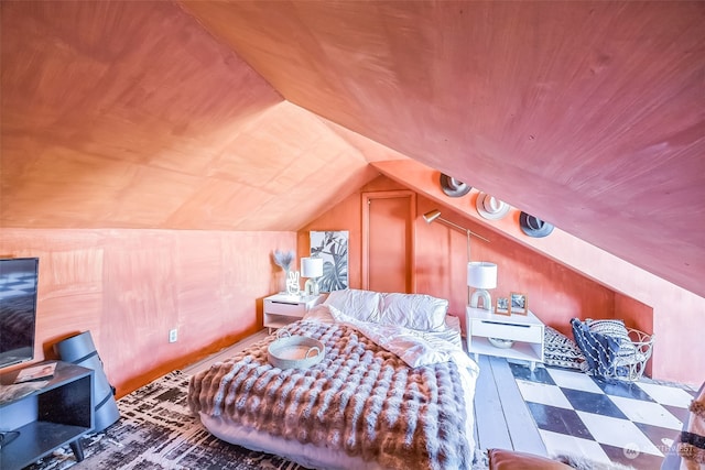 bedroom with vaulted ceiling and dark hardwood / wood-style flooring