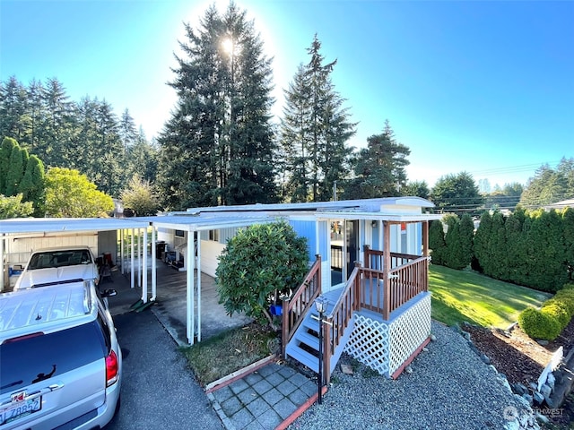 manufactured / mobile home featuring a carport and a front lawn