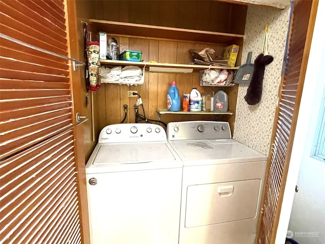 laundry room with wood walls and washing machine and dryer