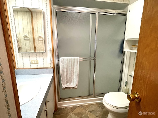 bathroom featuring tile patterned floors, walk in shower, vanity, and toilet